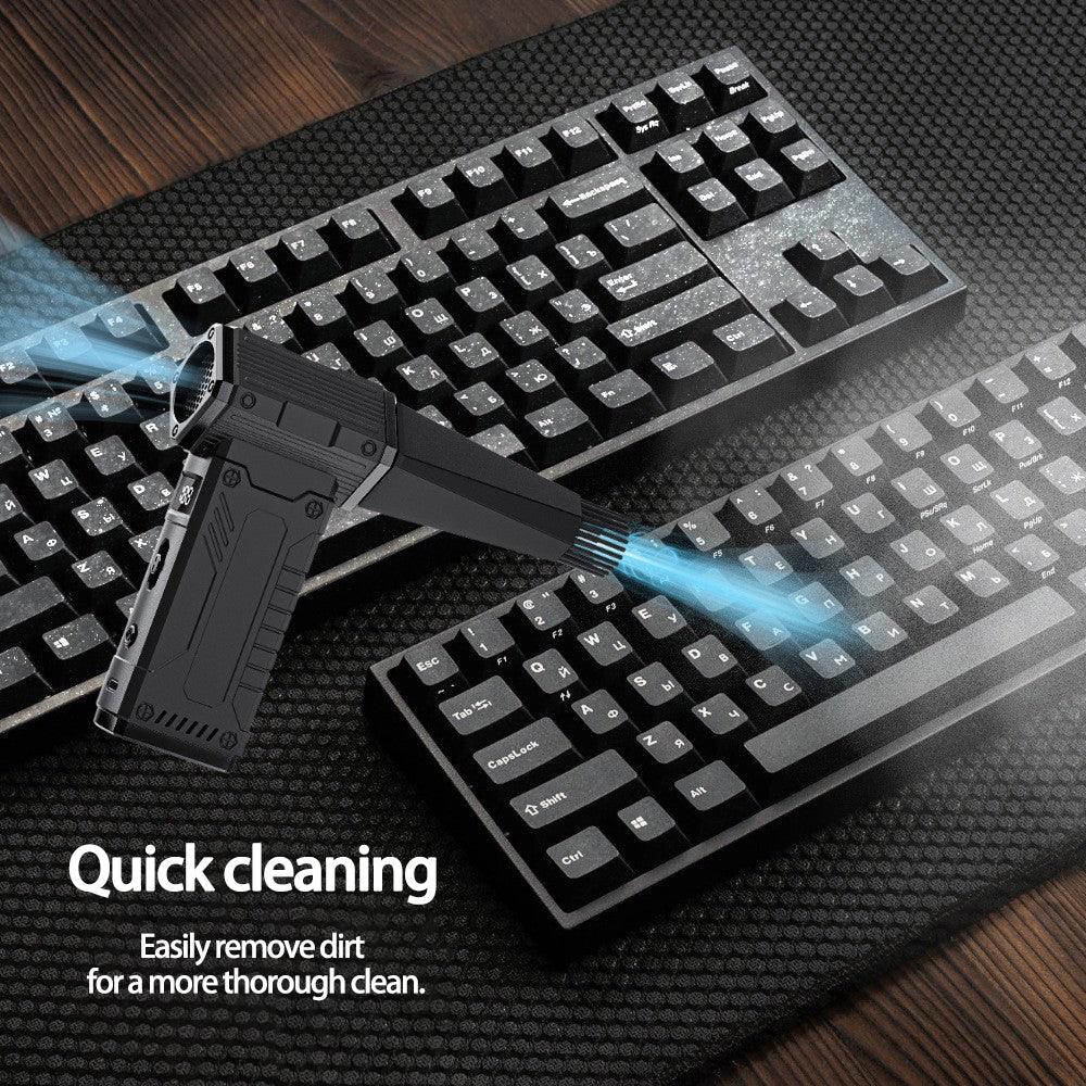 Handheld black keyboard cleaning device blowing dust off black mechanical keyboards on desk